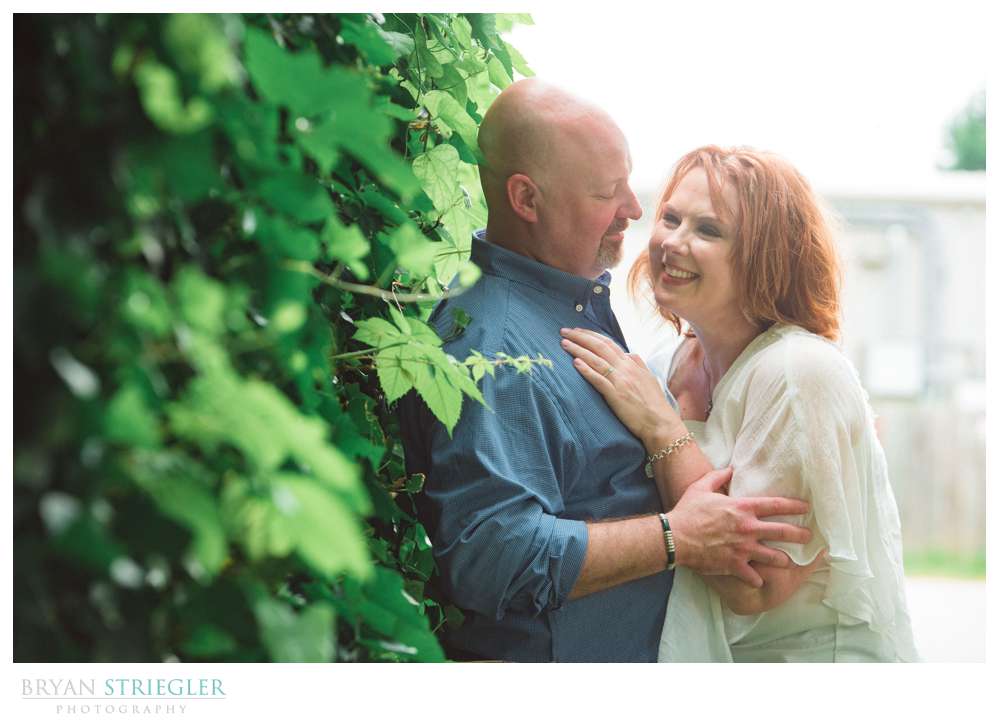 couple against a vine covered wall